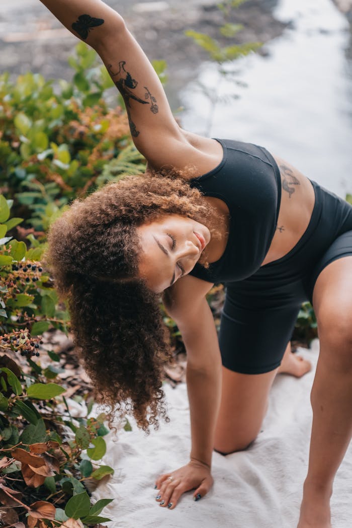 about-02 Woman stretching in activewear outdoors by a river, emphasizing wellness and nature.