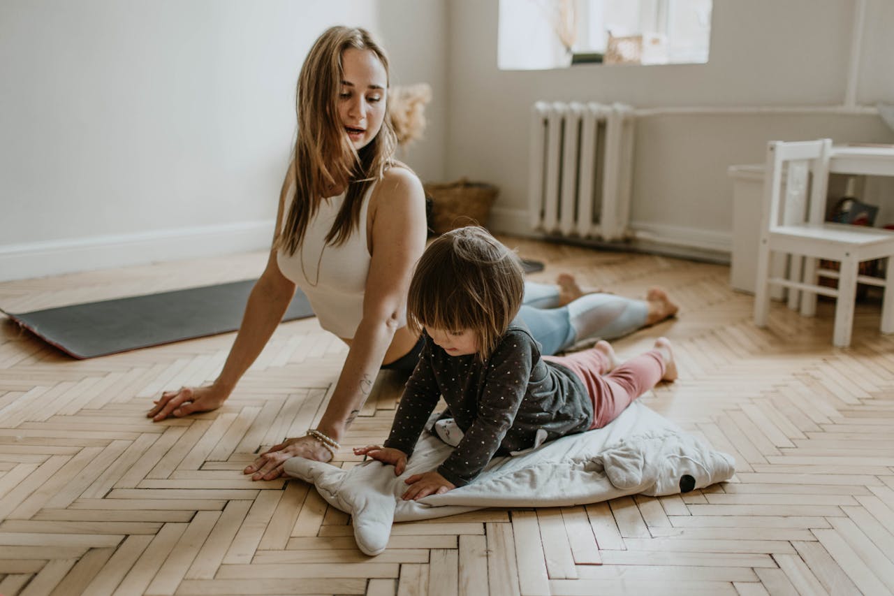 about-04 A mother and child practicing yoga together at home on a sunny day, fostering wellness and connection.